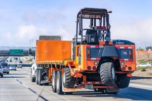 Truck carrying a forklift 